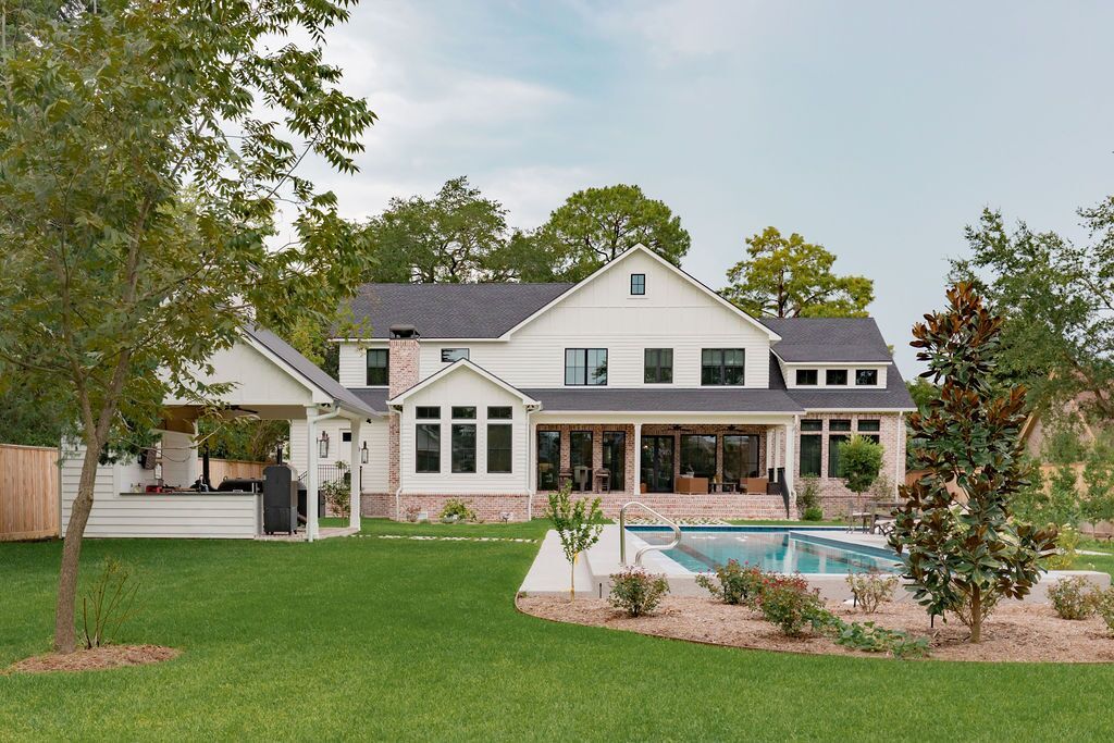 A large white house with a swimming pool in the backyard.
