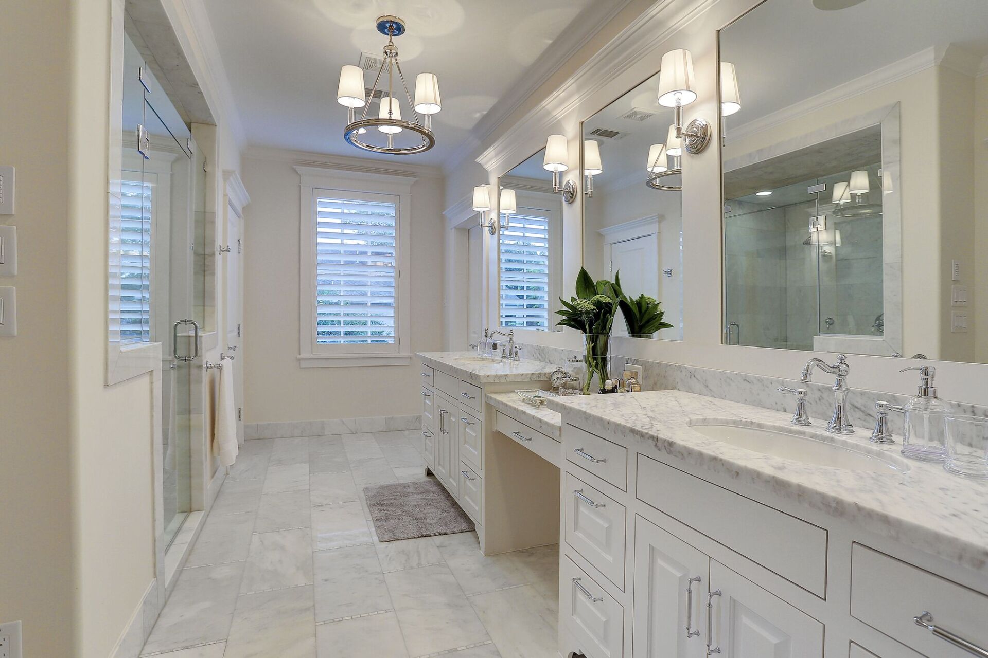 A bathroom with two sinks , two mirrors and a walk in shower.