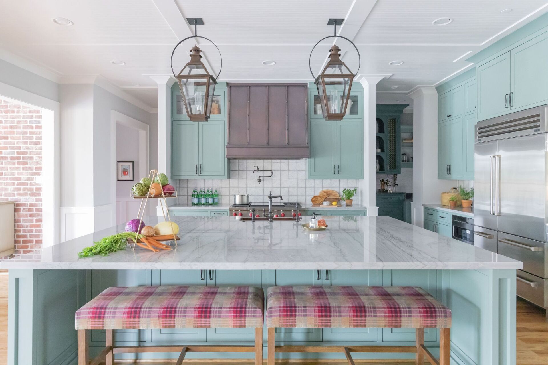 A kitchen with blue cabinets , white counter tops , and a large island.
