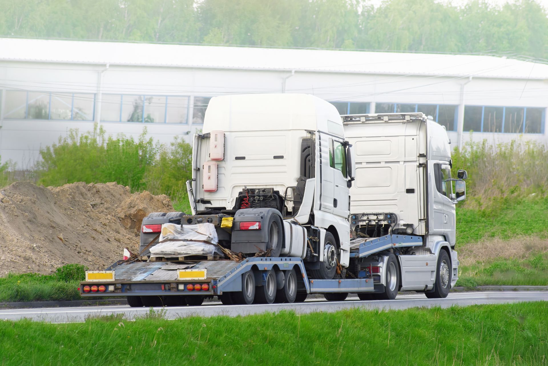 A Semi Truck With a Trailer is Driving Down a Road — Venus Couriers Pty Ltd In Mackay, QLD