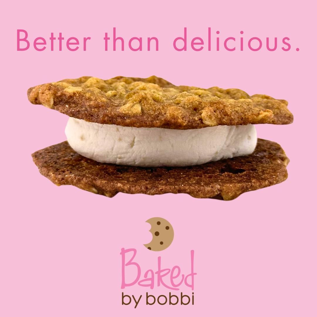 A cookie sandwich from baked by bobbi on a pink background