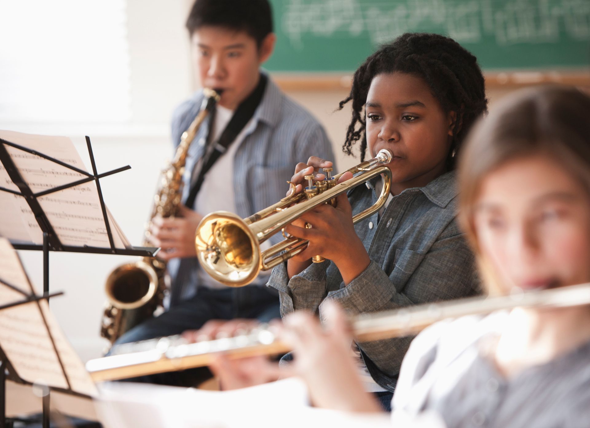 A young boy in a white shirt and tie is playing a saxophone. A young boy in a white shirt and tie is playing a saxophone.
