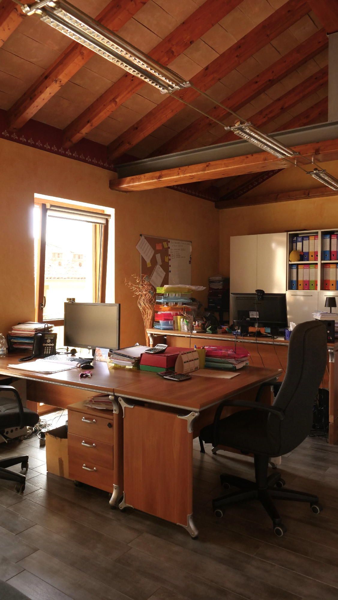 Una stanza con un sacco di scrivanie e sedie