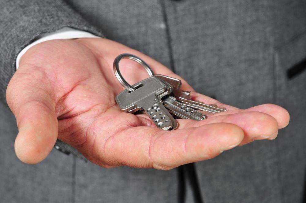 Hand Holding a Silver Keyring With Several Keys and a Padlock — MoneySmith Group In Kingscliff, NSW