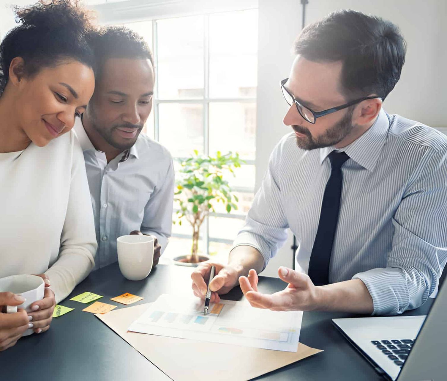 A Man is Sitting at a Table With a Woman and a Man — MoneySmith Group In Northern Rivers, NSW