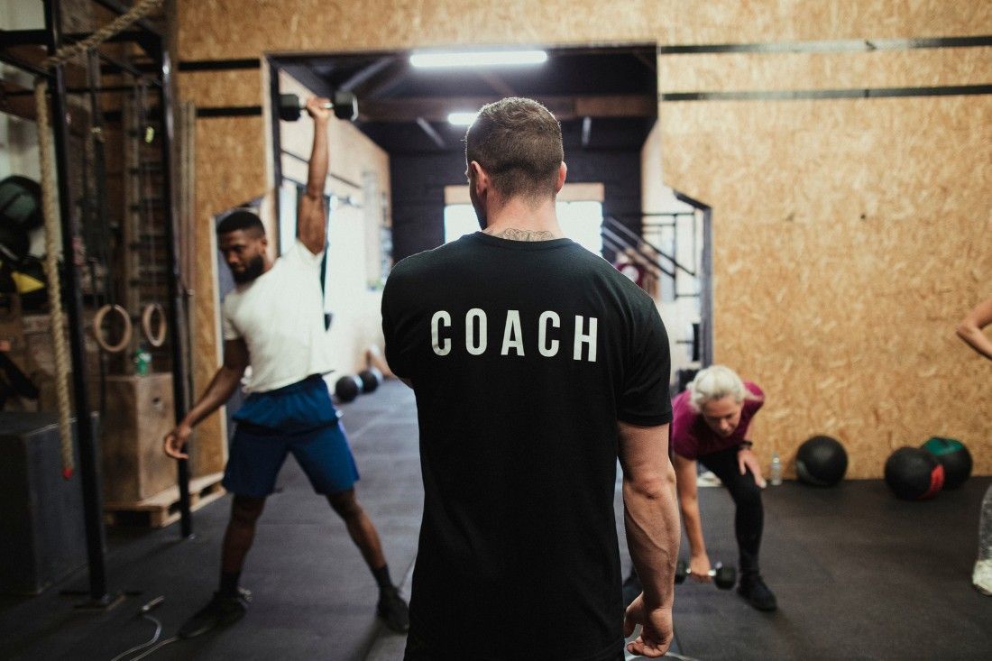 A Man Wearing a Coach Shirt is Standing in a Gym — MoneySmith Group In Kingscliff, NSW