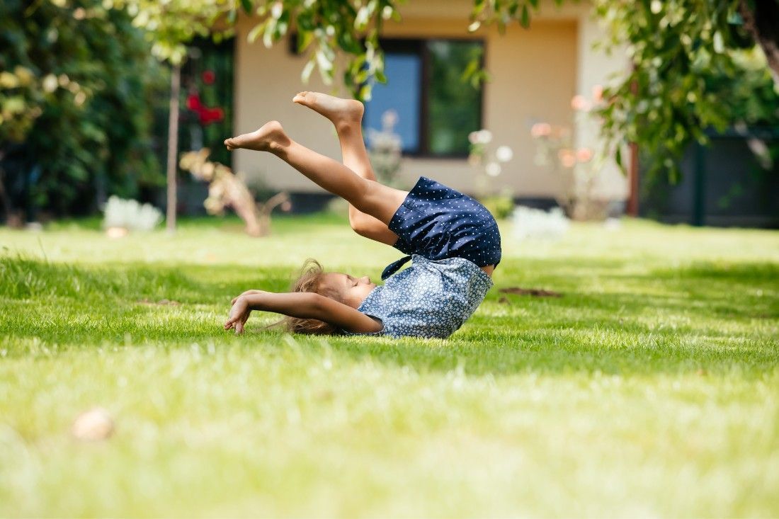 A Little Girl is Doing a Handstand in the Grass — MoneySmith Group In Kingscliff, NSW