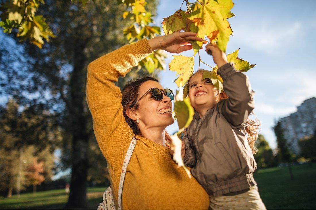 A Woman and a Child Are Picking Leaves From a Tree — MoneySmith Group In Kingscliff, NSW