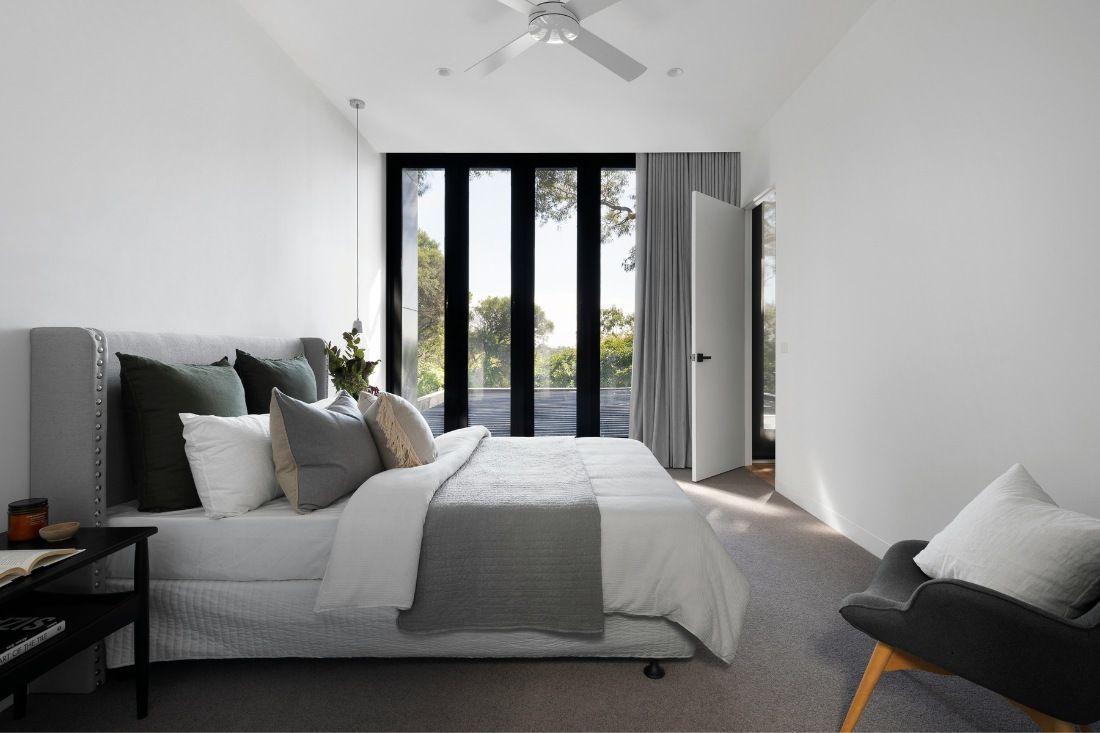 A Bedroom With a Large Bed and a Ceiling Fan — MoneySmith Group In Kingscliff, NSW