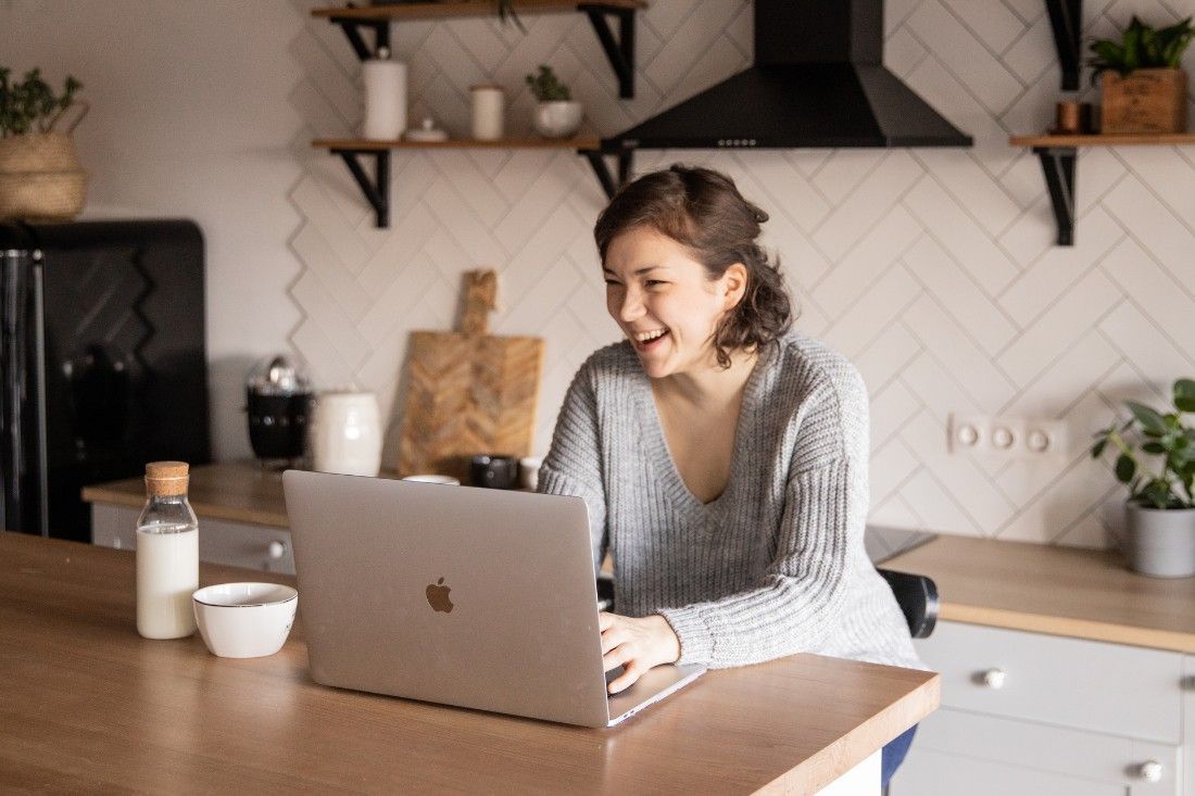 A Woman is Sitting at a Kitchen Counter — MoneySmith Group In Kingscliff, NSW