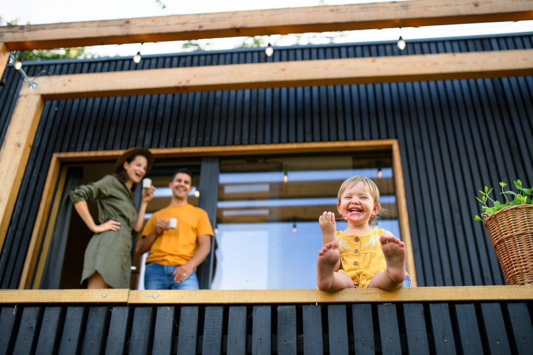 A Family Is Standing On A Balcony — MoneySmith Group In Kingscliff, NSW