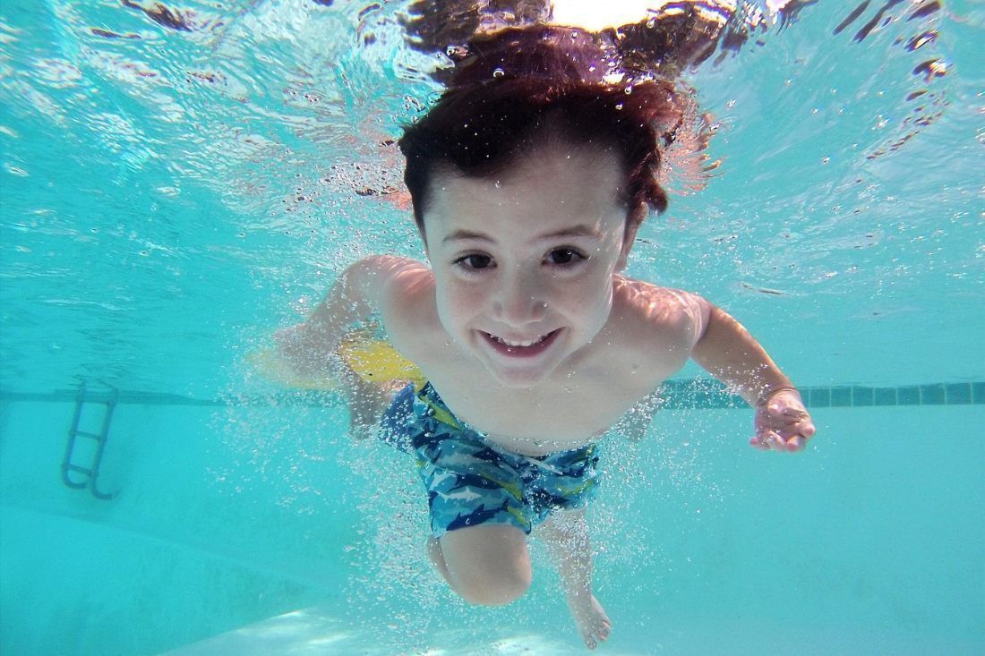 A Young Boy Is Swimming Underwater In A Swimming Pool — MoneySmith Group In Kingscliff, NSW