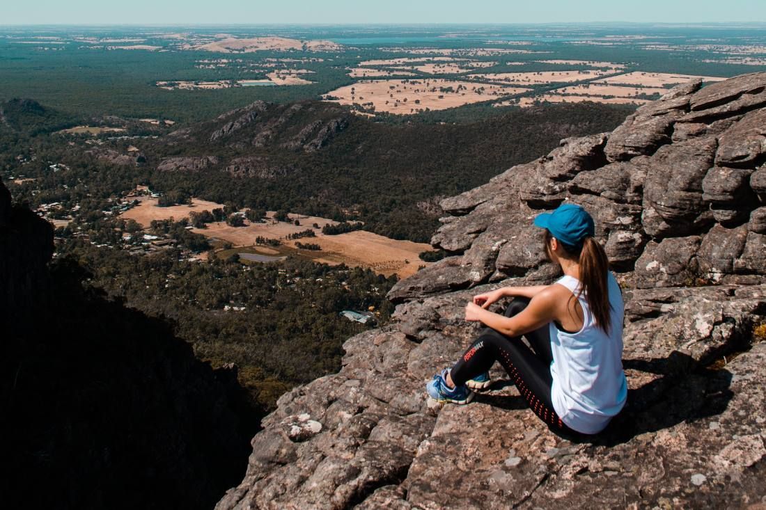 A Woman is Sitting on the Edge of a Mountain — MoneySmith Group In Kingscliff, NSW