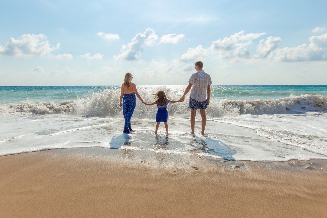 A Family is Walking on the Beach Holding Hands — MoneySmith Group In Kingscliff, NSW
