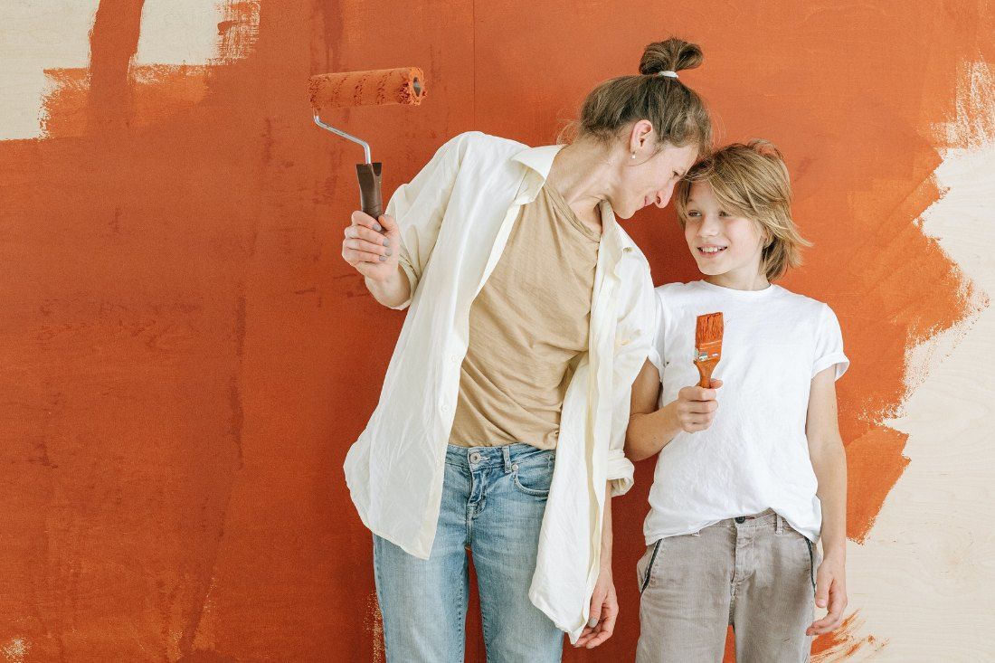 A Woman and a Child Are Painting a Wall Together — MoneySmith Group In Kingscliff, NSW