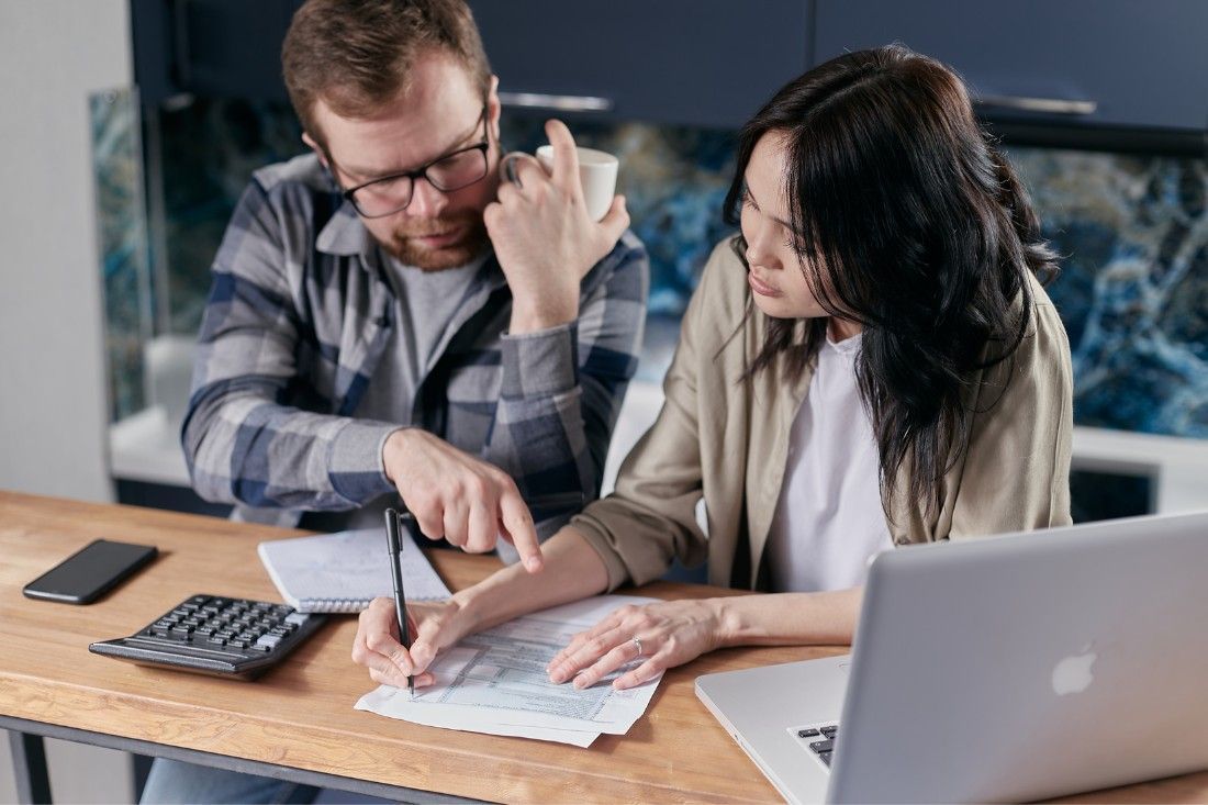 A Man and a Woman Are Sitting at a Table — MoneySmith Group In Kingscliff, NSW