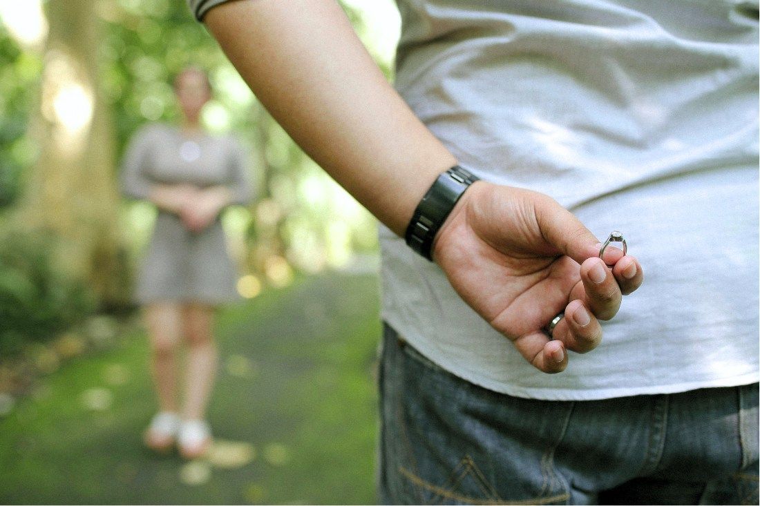 A Man is Holding a Wedding Ring Behind His Back — MoneySmith Group In Kingscliff, NSW