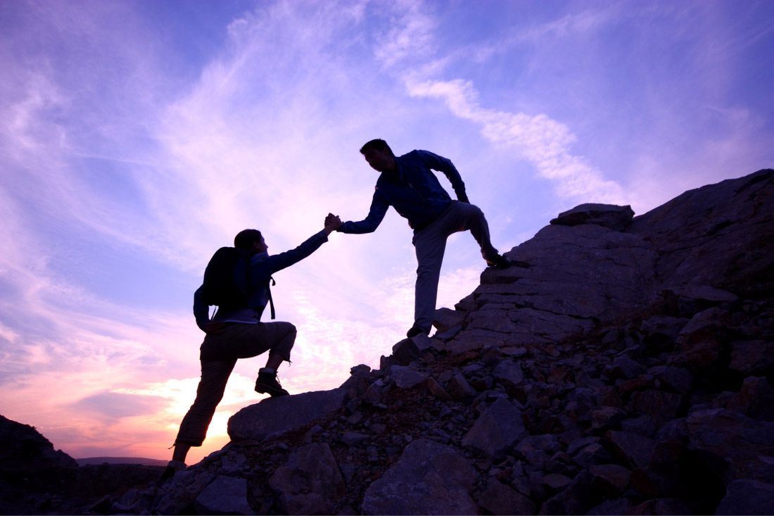 A Man is Helping Another Man Climb a Mountain — MoneySmith Group In Kingscliff, NSW