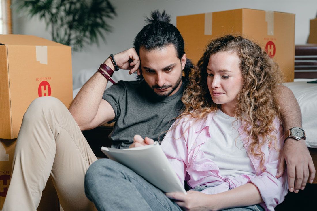 A Man and a Woman Are Sitting on the Floor Looking at a Tablet — MoneySmith Group In Kingscliff, NSW