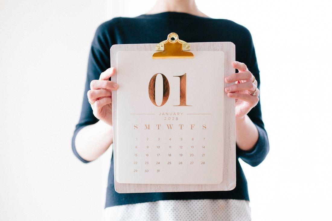 A Woman Is Holding A Clipboard With A Calendar On It — MoneySmith Group In Kingscliff, NSW