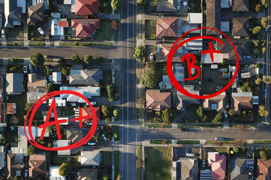 Aerial view of a residential street with two houses circled in red and labeled
