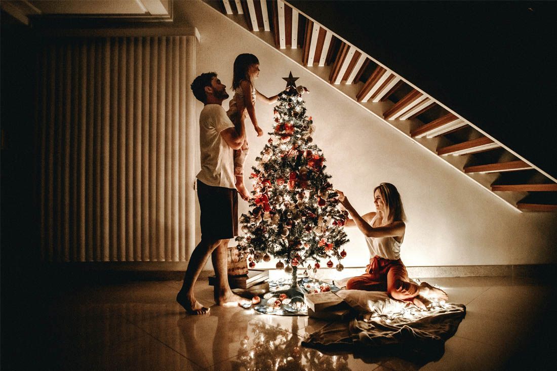 A Family Is Decorating A Christmas Tree — MoneySmith Group In Kingscliff, NSW