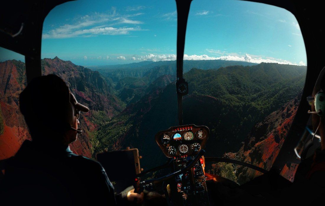 A Man is Flying a Helicopter Over a Mountain Range — MoneySmith Group In Kingscliff, NSW