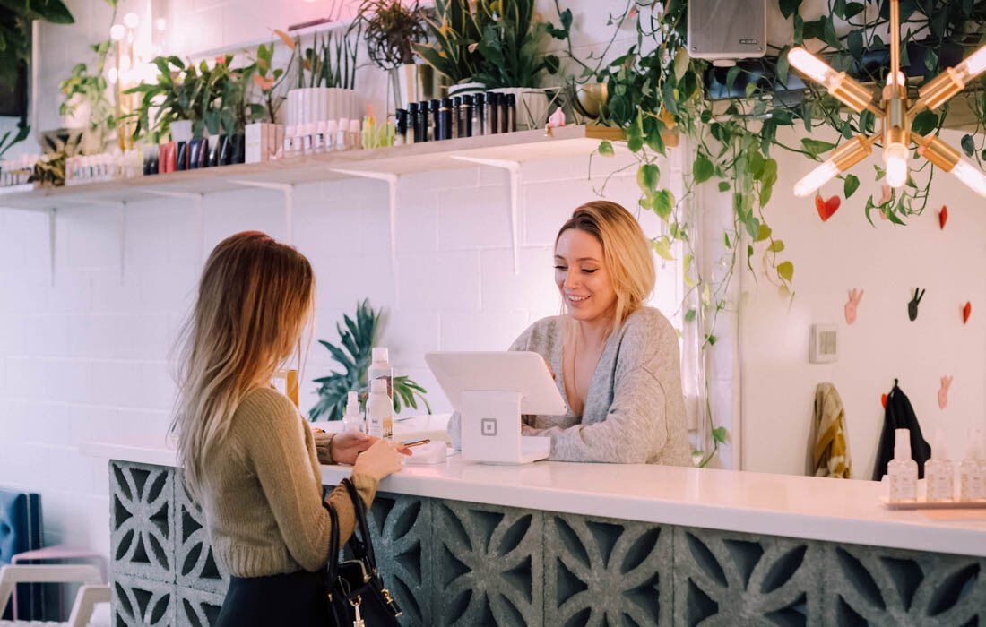 Two Women Are Standing at a Counter — MoneySmith Group In Kingscliff, NSW