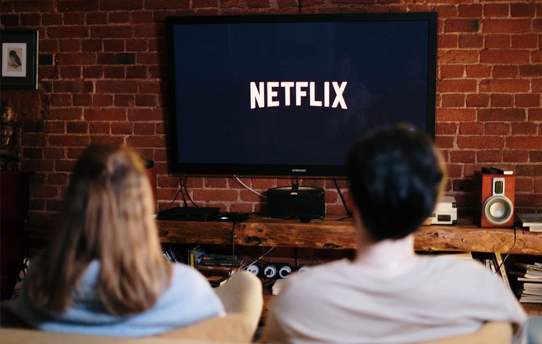 Couple Are Sitting on a Couch Watching Netflix — MoneySmith Group In Kingscliff, NSW