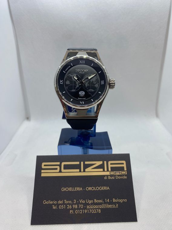 Un orologio da polso con il quadrante nero su un espositore davanti a un biglietto da visita.