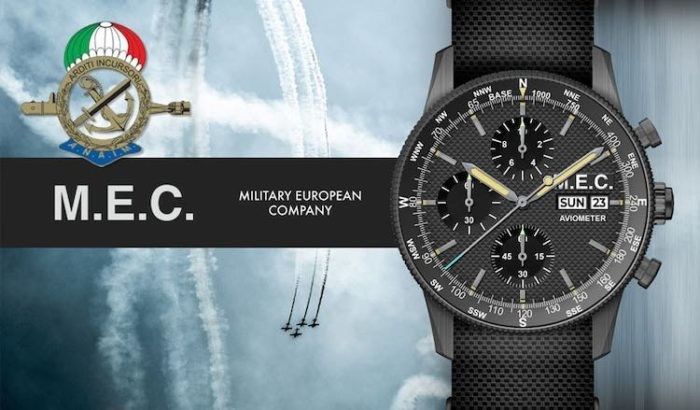 Orologio MEC con quadrante nero, cronografo e indicatore giorno/data. Presenta insegne militari italiane e jet sullo sfondo.