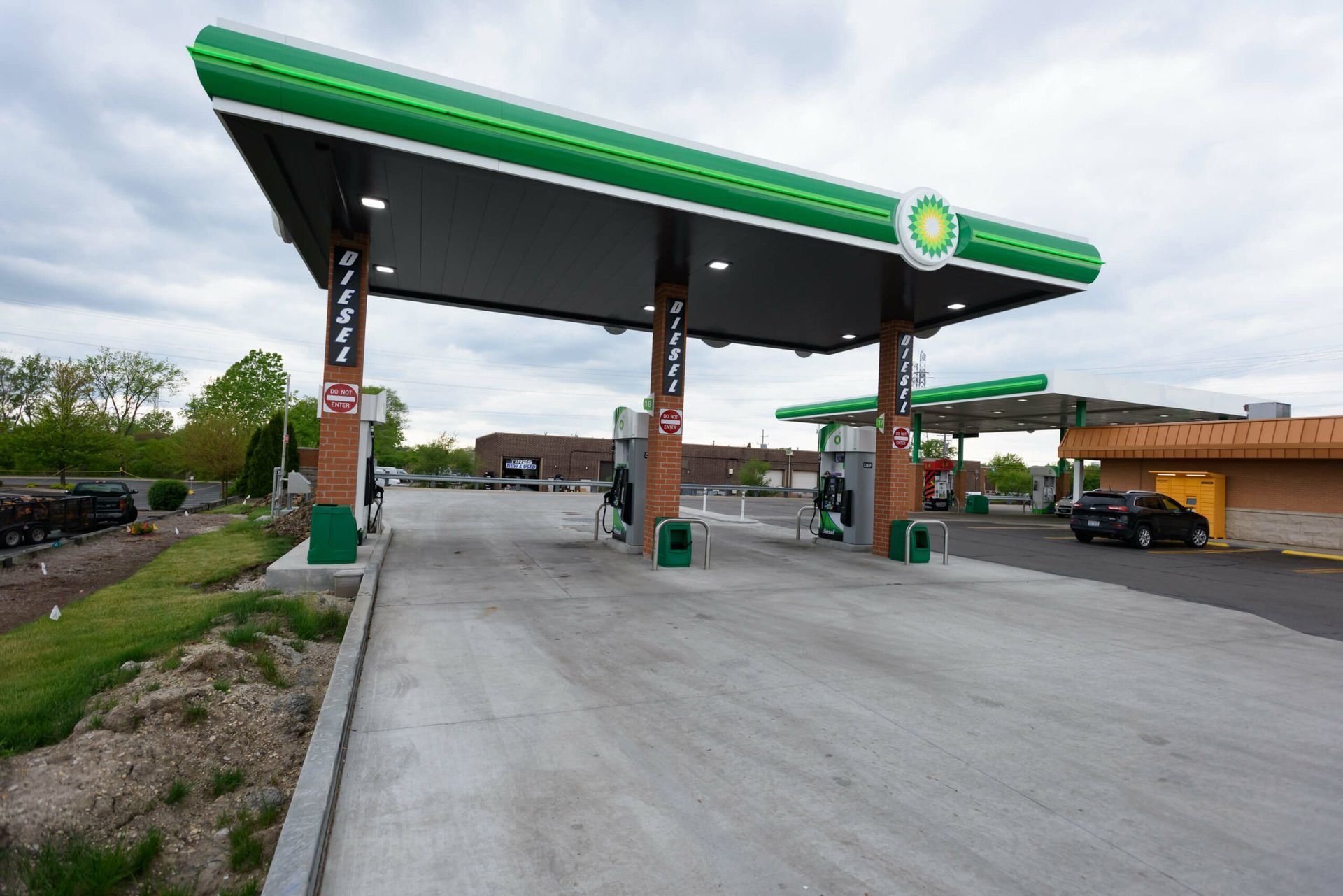 A bp gas station with a concrete driveway in front of it.