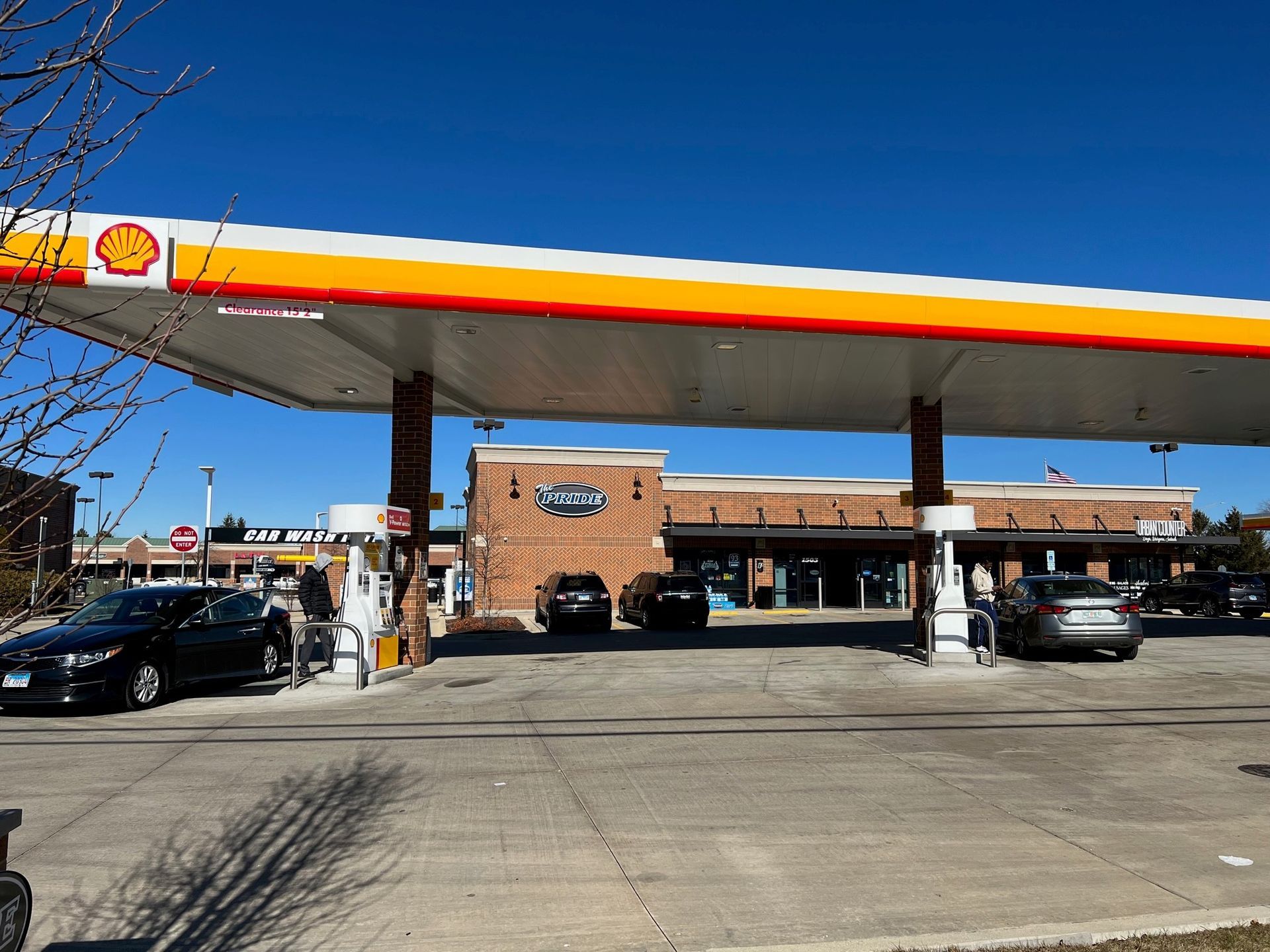 A shell gas station with cars parked underneath it