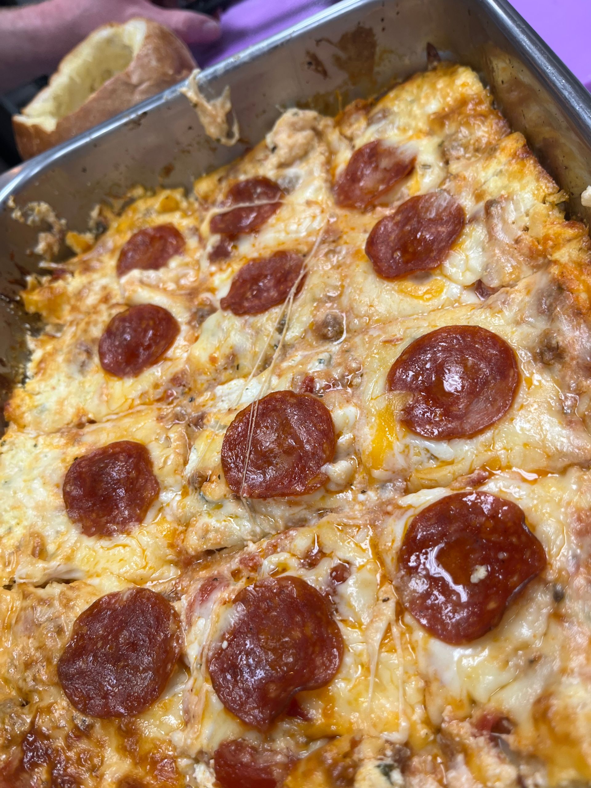 Pepperoni pizza in a baking pan, with melted cheese and a golden crust