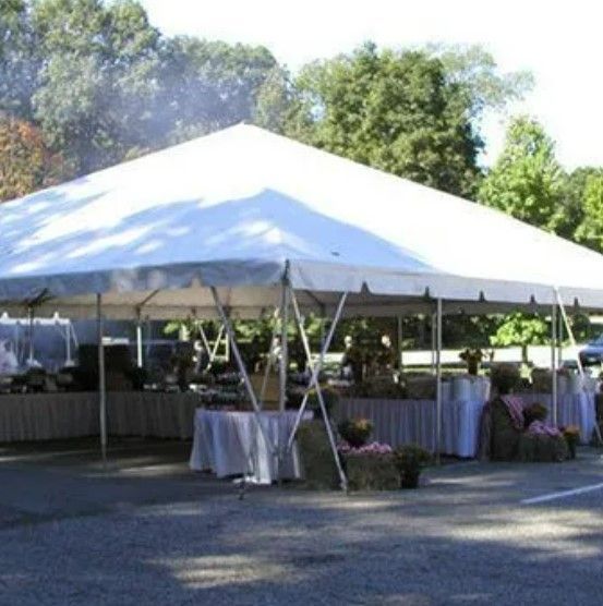 A large white tent with tables underneath it