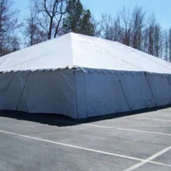 A large white tent is sitting in a parking lot.