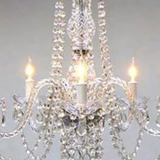 A close up of a chandelier with candles hanging from it.