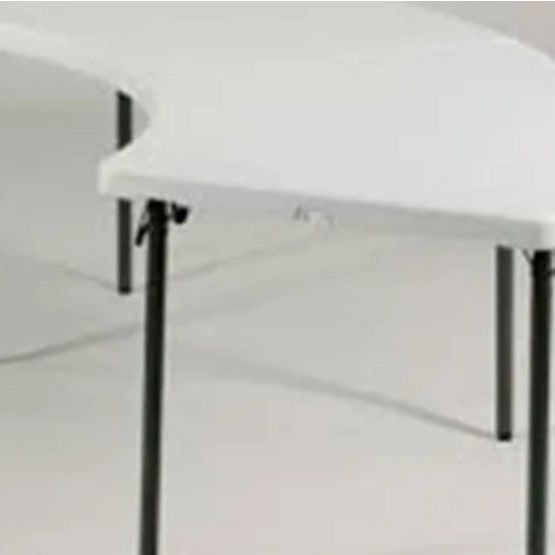 Two white tables with black legs are sitting next to each other on a white floor.