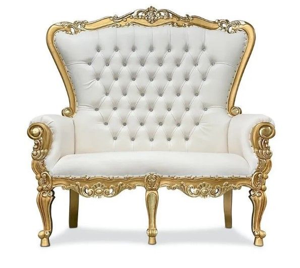 A white and gold couch with a tufted back