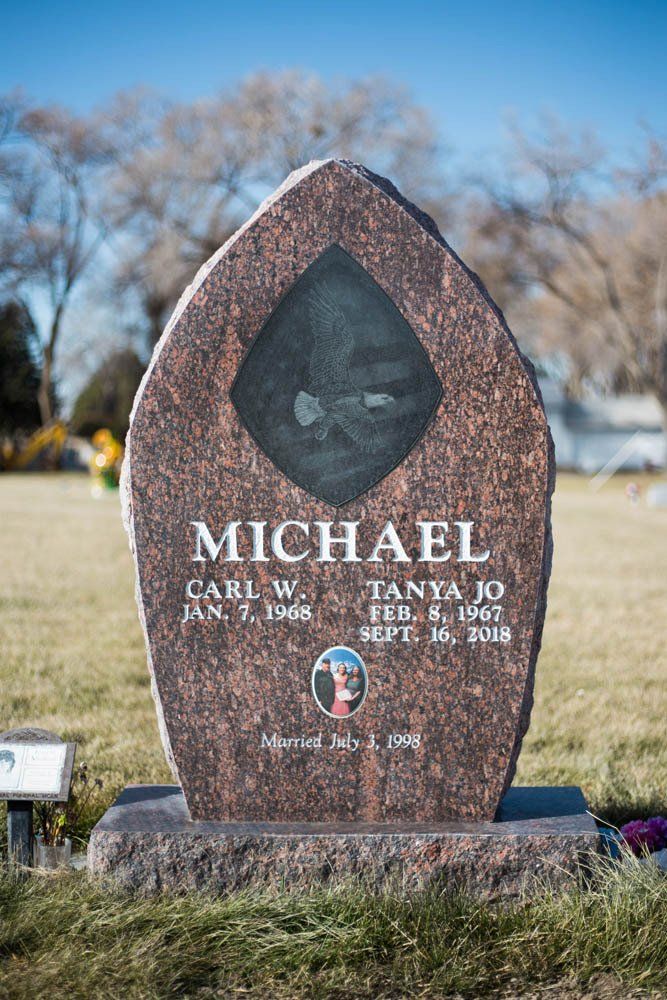 Frontal view of Michael family monument with reddish granite, eagle engraving, and photo medallion