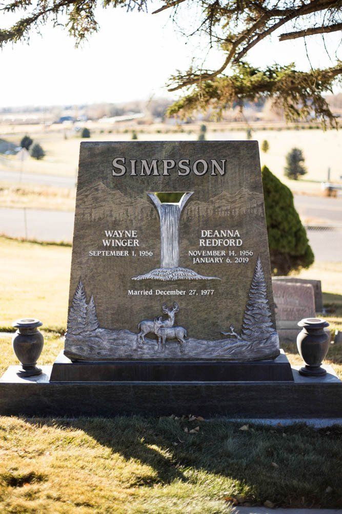 Centered view of Simpson monument featuring forest scenery and engraved deer