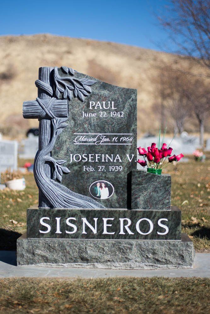 Full view of Signoreos family monument with wrapped cross and red flower vase
