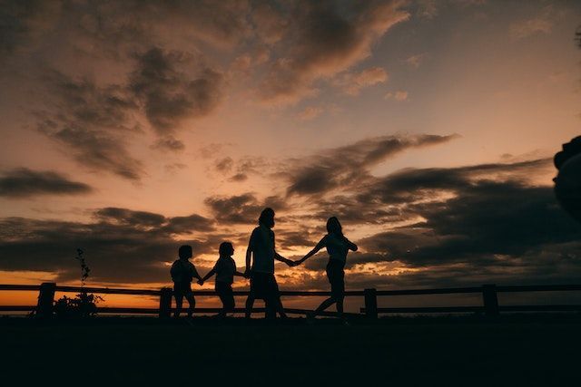 A family holding hands at dusk on a beach