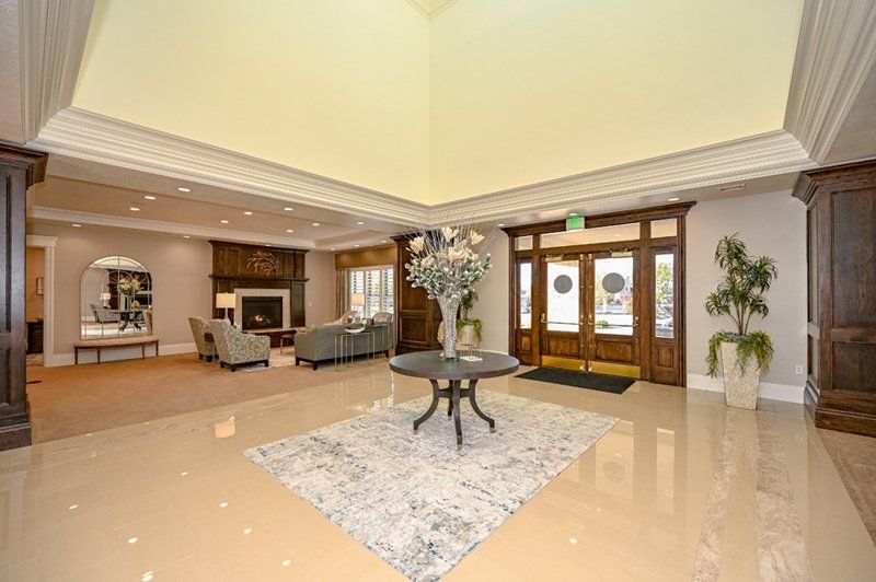 Spacious lobby at White Pine Funeral Services in Logan, UT with marble floors, a fireplace seating area, and floral centerpiece