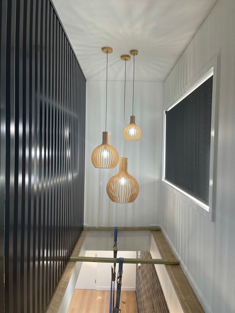 A hallway with three pendant lights hanging from the ceiling.