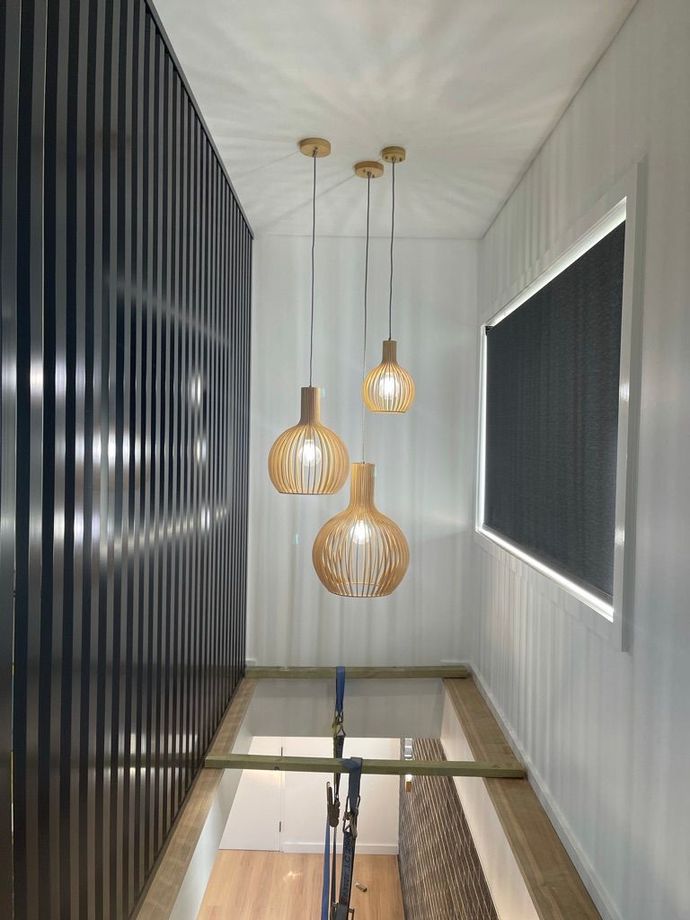 A hallway with three pendant lights hanging from the ceiling.