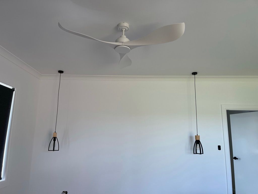 A white ceiling fan is hanging from the ceiling of a room.