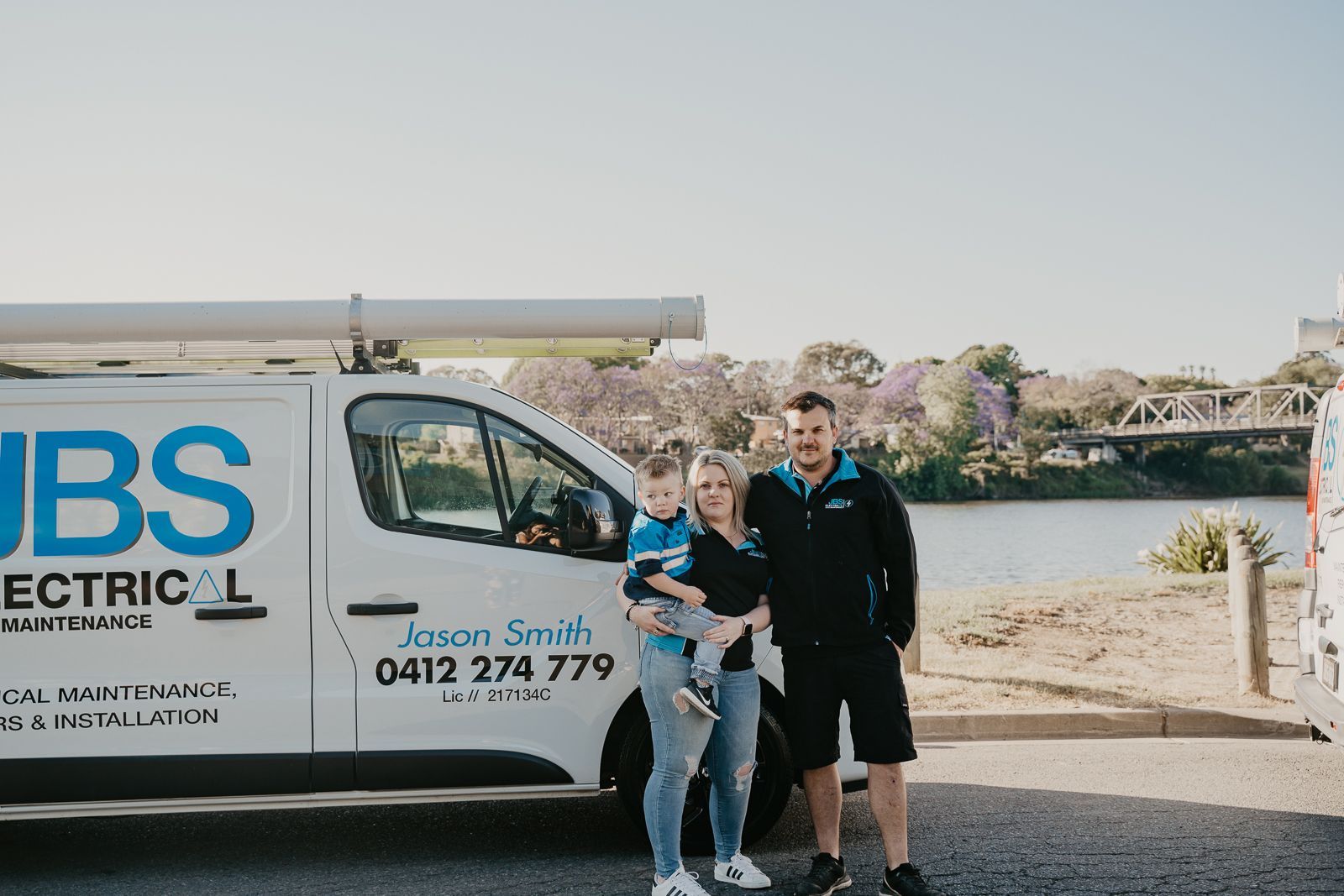 A family is standing in front of a van.