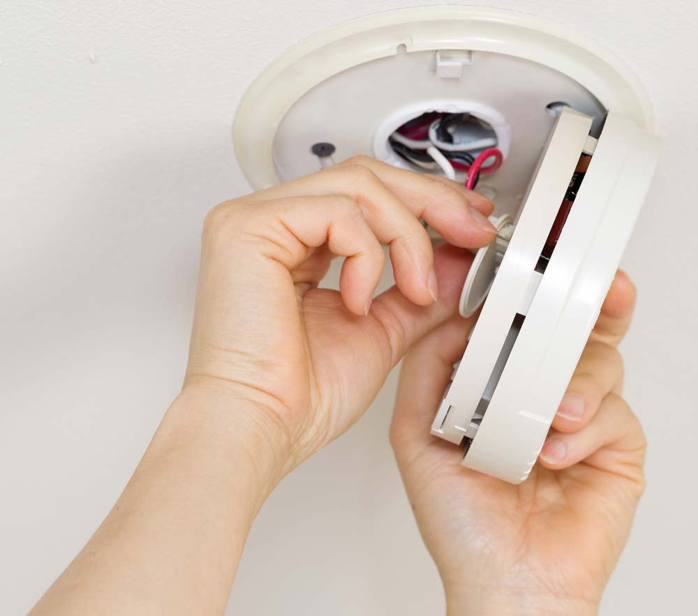 Worker Installing Smoke Detector — Electrician in Kempsey, NSW