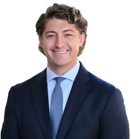 Smiling person in a navy suit and blue tie on a white background